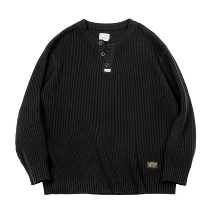Flatlay of black ribbed Henley knit sweater with button neckline.