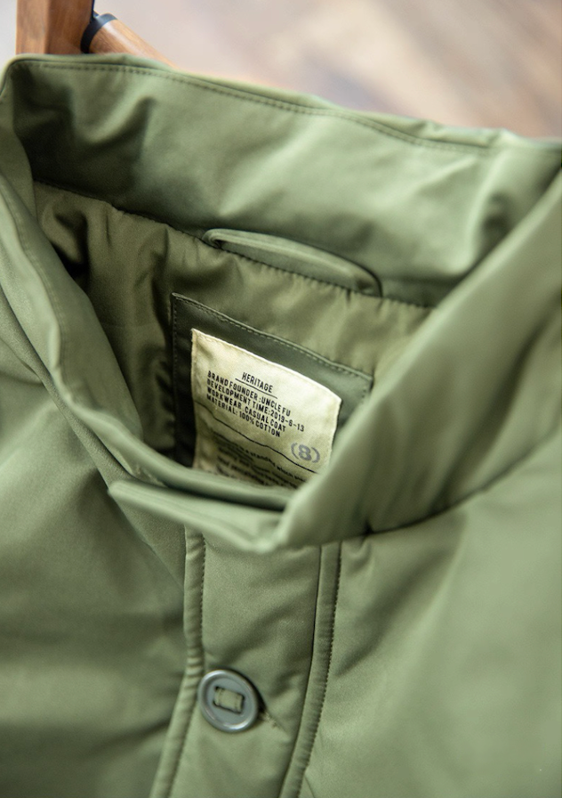 Close-up of inner stand collar and woven label on army green jacket.