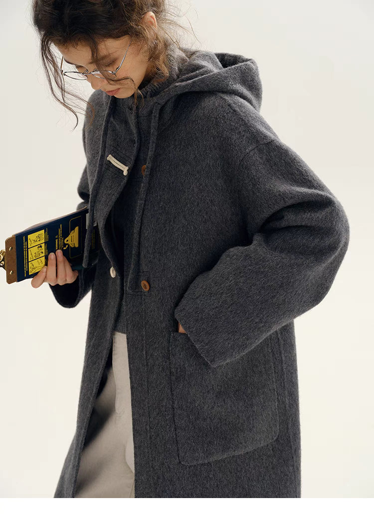 Close-up of Highland Wool Toggle Coat in dark gray highlighting toggle closures, front patch pocket, hood detail, and soft wool texture