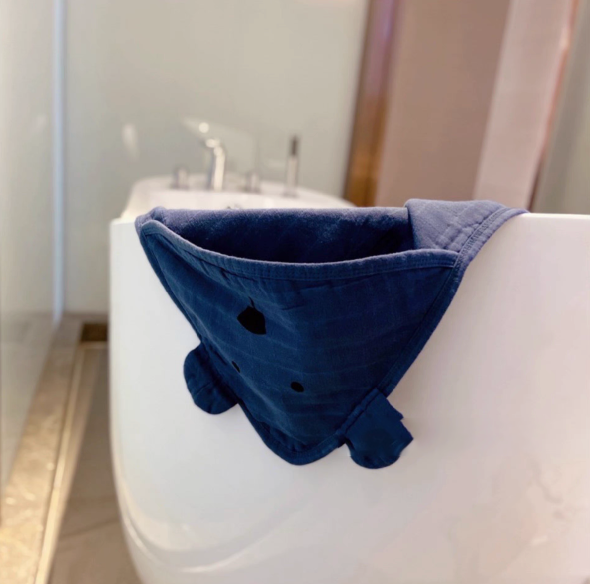 Bear Navy Blue hooded baby swaddle wrap draped over bathtub showing soft breathable cotton muslin material