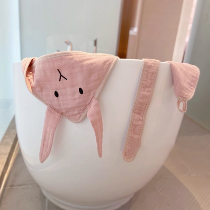 Bunny Soft Pink hooded baby swaddle wrap with matching belt draped over bathtub highlighting breathable fabric