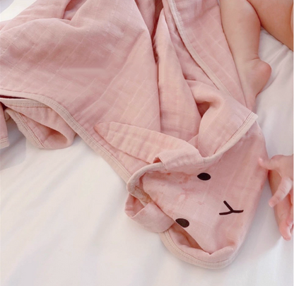 Bunny Soft Pink baby swaddle wrap close-up showing soft cotton muslin texture and hood detail on baby