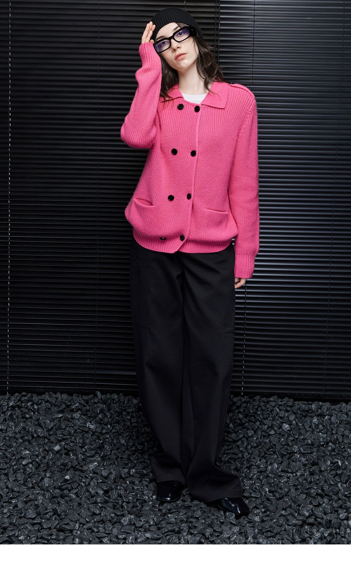 Woman in Hot Pink double-breasted rib knit cardigan with black beanie and wide-leg black trousers, full-length view