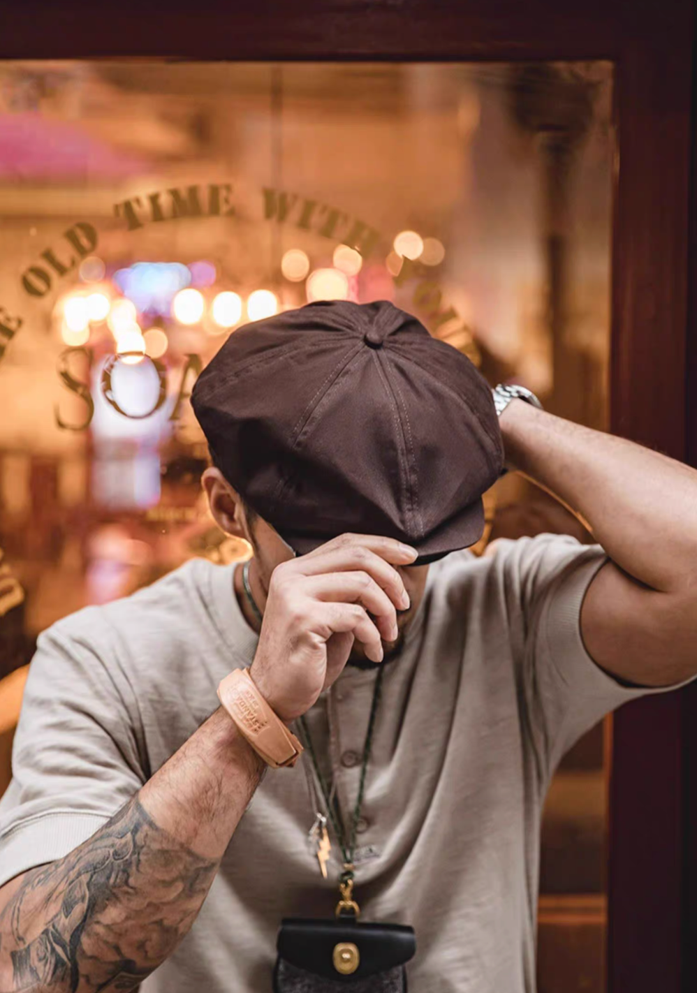 Hudson Cotton Blend Newsboy Cap in coffee red worn front view with hand adjusting brim showcasing structured panel design textured cotton fabric and classic vintage style