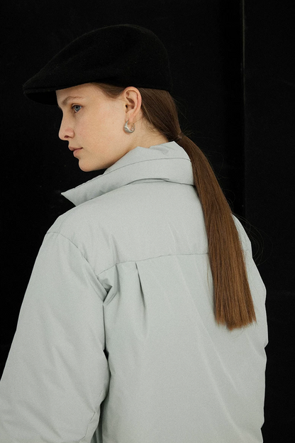 Back view of an Ice Blue down jacket showing the yoke seam and center box pleat