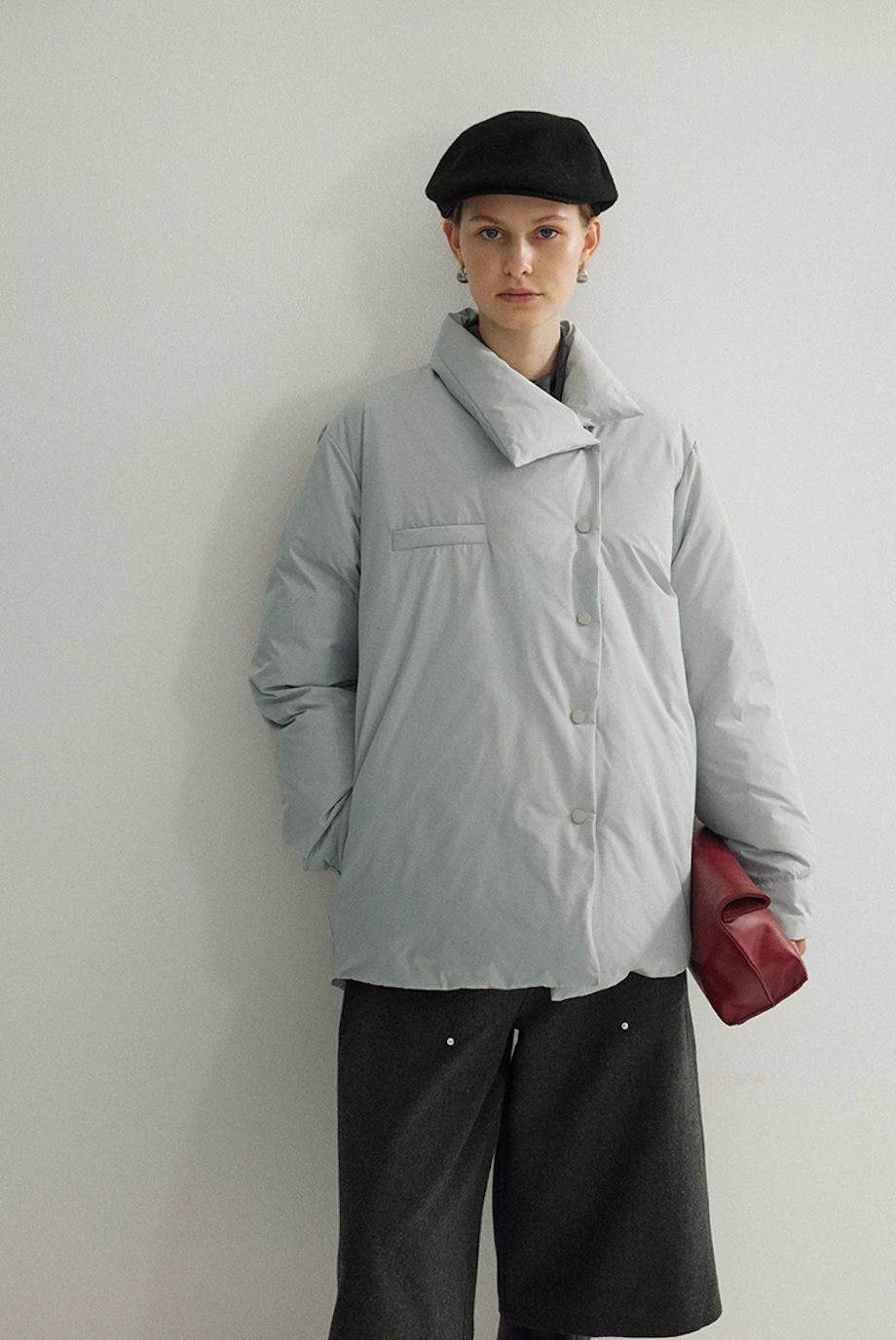 Ice Blue down jacket snapped closed along the asymmetric placket, with folded collar