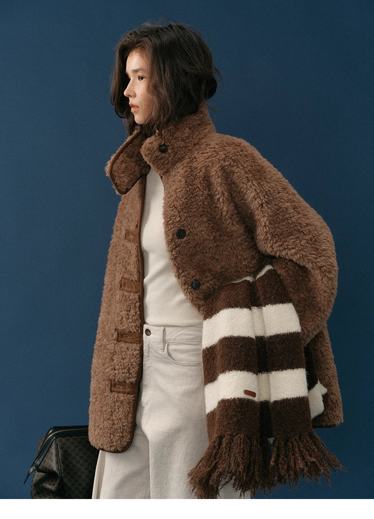 Side profile of model wearing chocolate teddy coat with high stand collar and striped scarf.