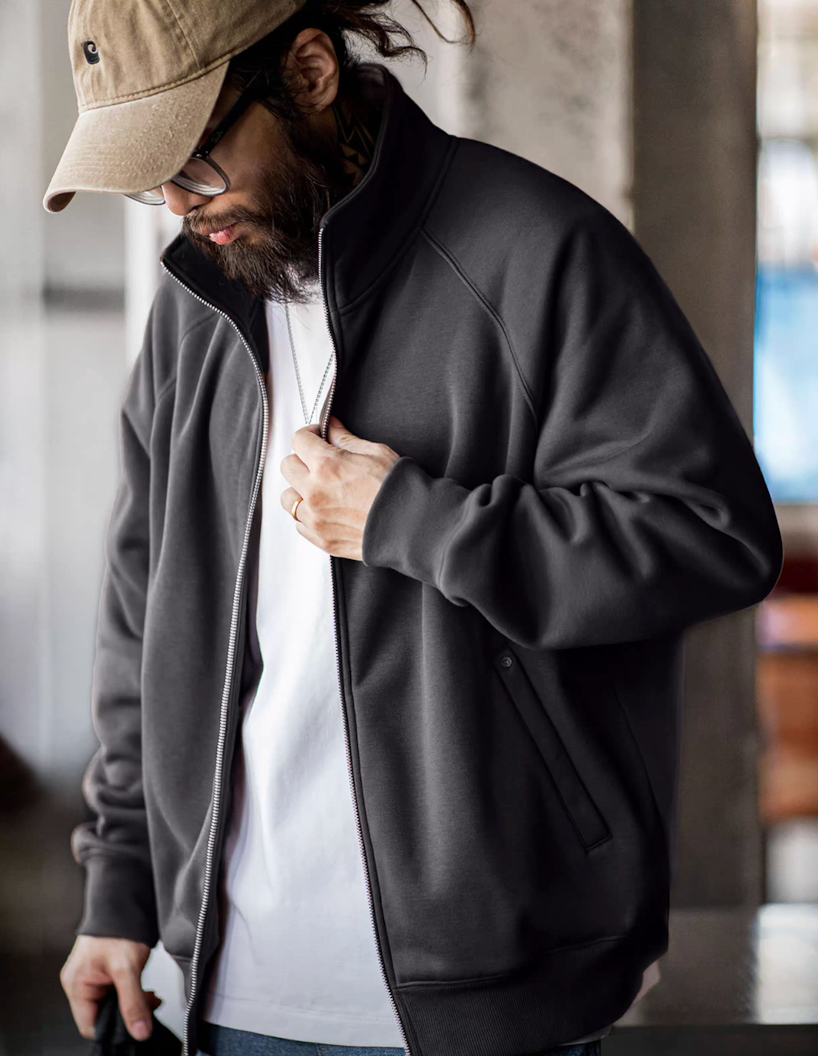 Model wearing charcoal stand-collar fleece jacket, half-zipped