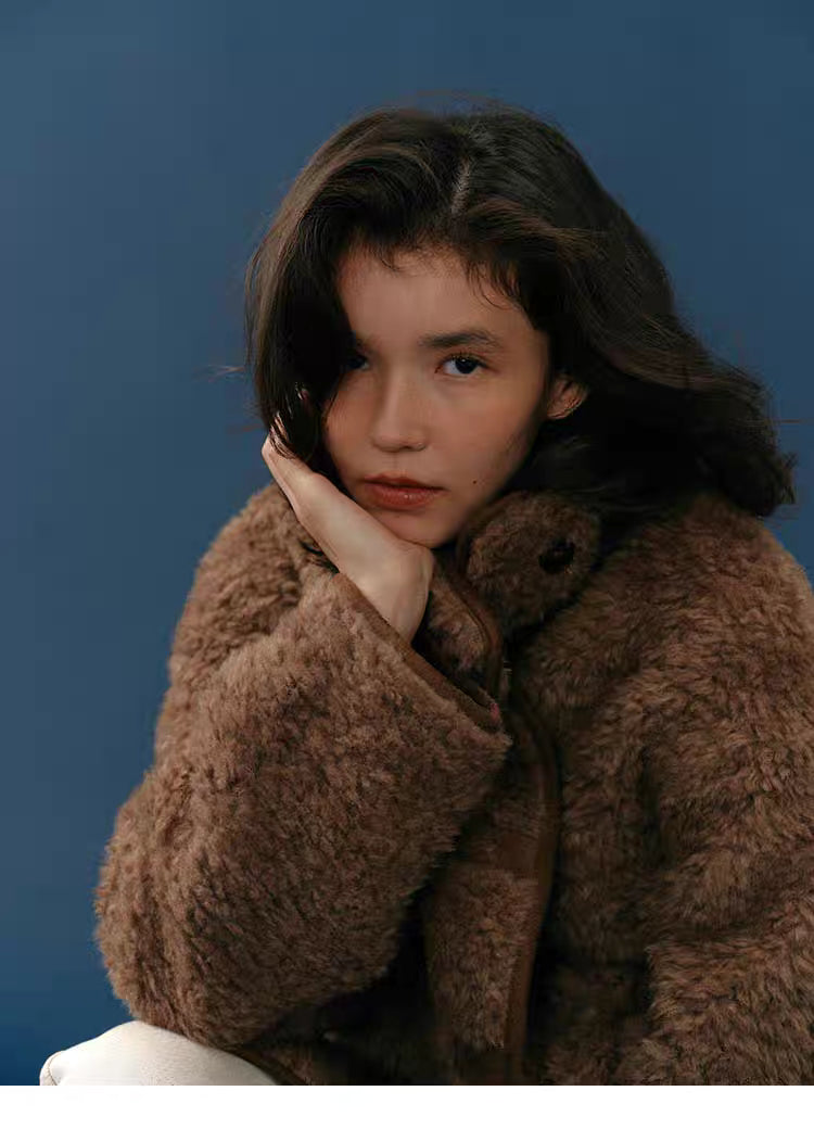 Close-up portrait showing plush textured chocolate teddy coat and high collar.