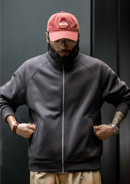 Charcoal fleece zip jacket on model with hands in pockets, raglan sleeves