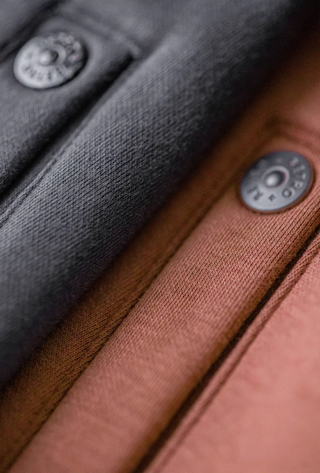 Close-up of double-fleece fabric—smooth knit outside and plush inside, charcoal and clay