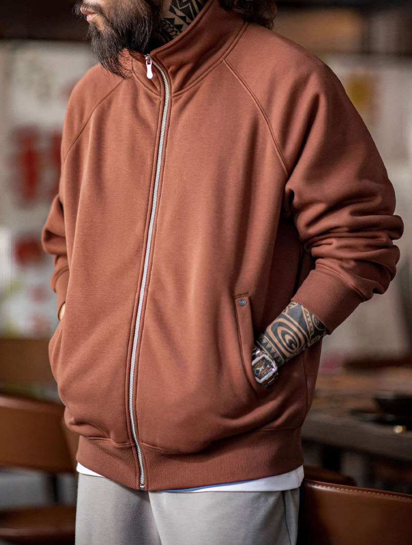 Model wearing warm clay stand-collar fleece jacket with hands in pockets