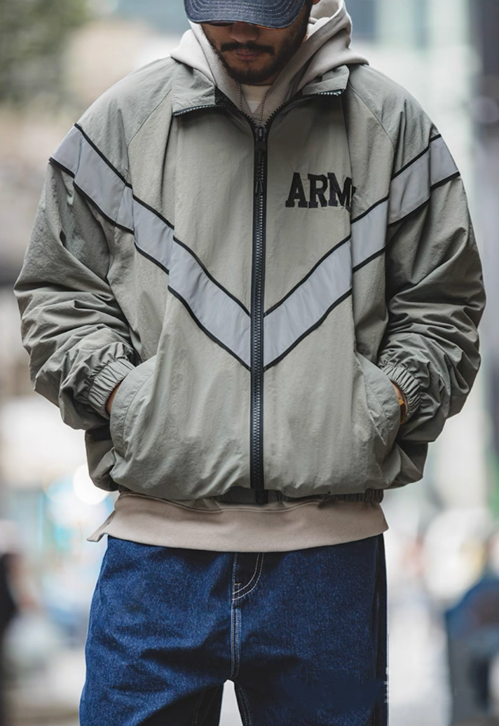 Model wearing khaki gray ARMY training jacket zipped up, reflective stripes visible.