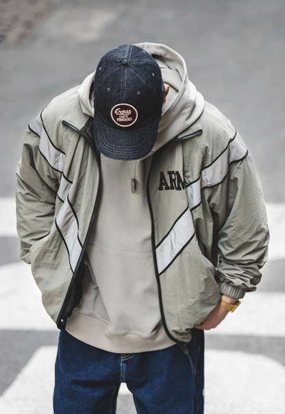 Model layering khaki gray ARMY training jacket over hoodie, looking downward.