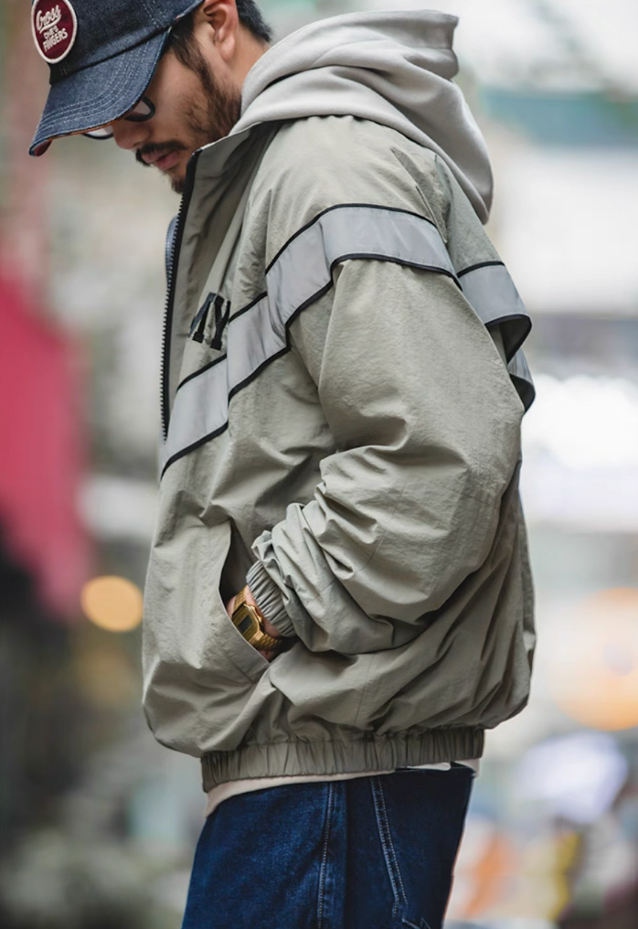 Side profile of model wearing khaki gray ARMY training jacket with reflective stripe.