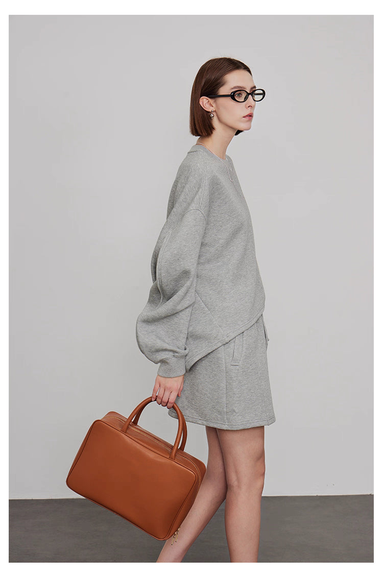 Side view of women’s grey oversized sweatshirt with mini skirt