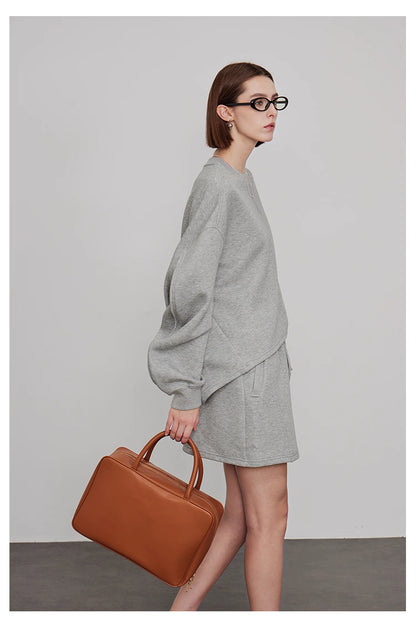 Side view of women’s grey oversized sweatshirt with mini skirt