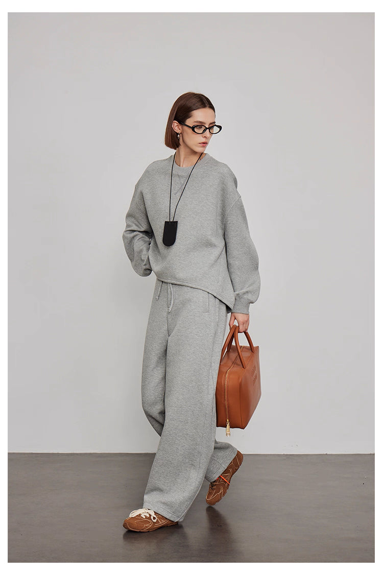 Model walking in grey sweatshirt and wide-leg pants outfit
