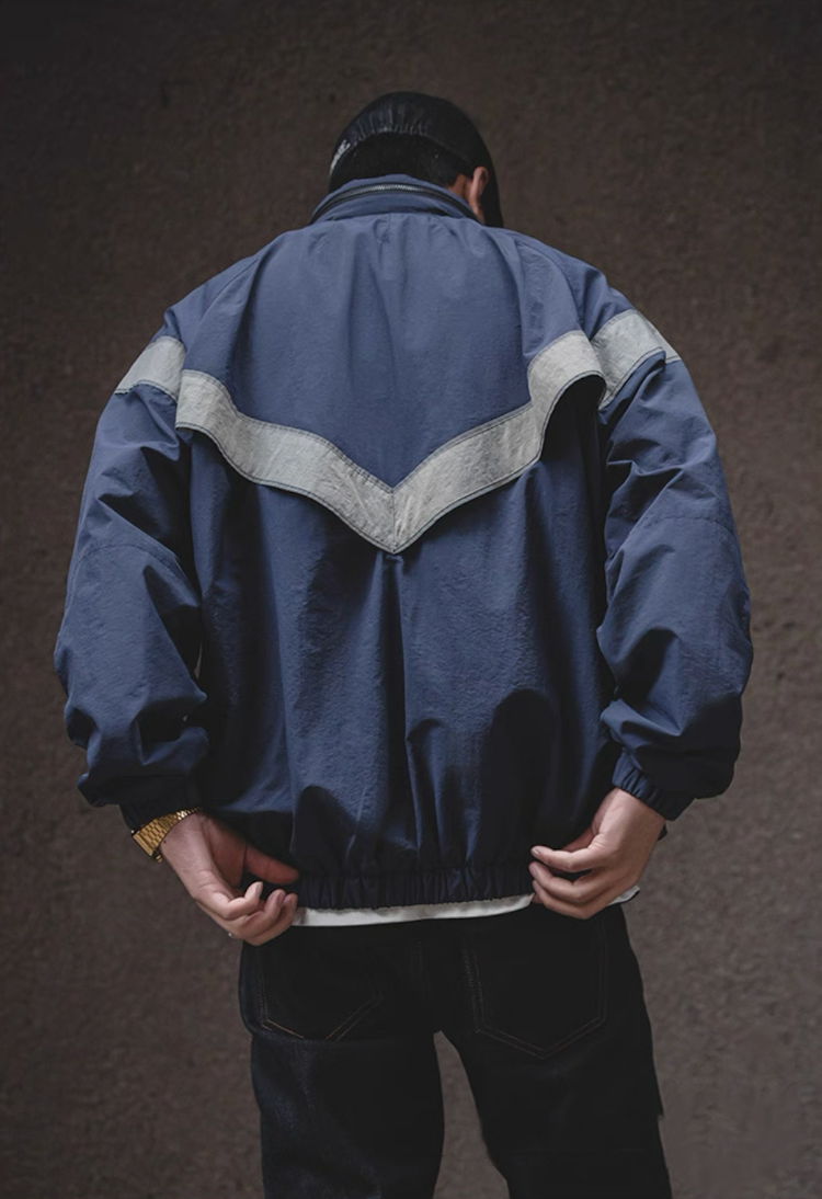 Back view of navy blue AIR FORCE training jacket showing reflective V-stripe.