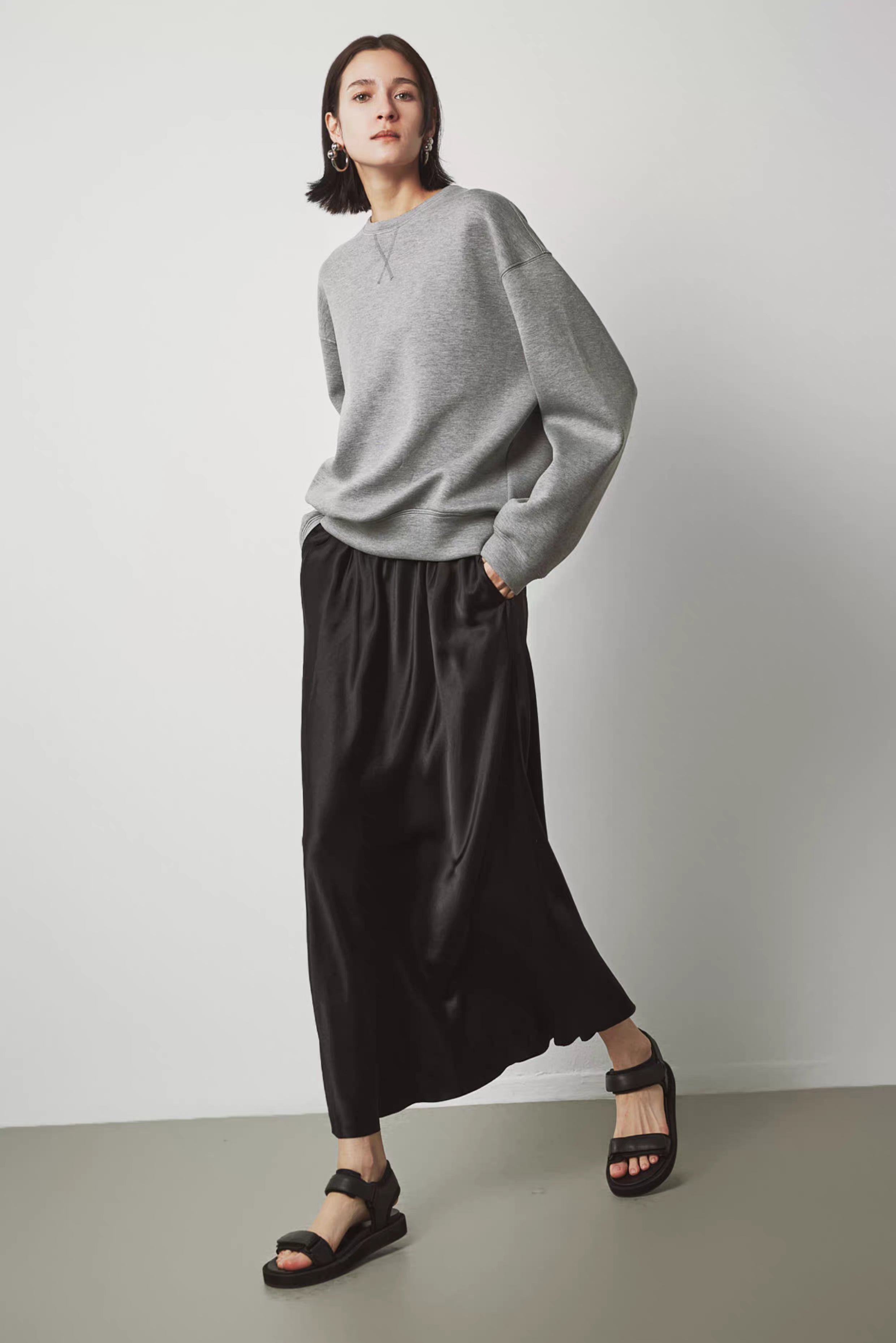 Women’s oversized gray sweatshirt styled with black long skirt – relaxed street style