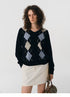 Front view of navy V-neck wool sweater with light blue and beige argyle pattern.
