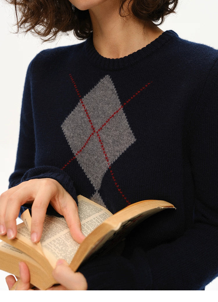 Close-up of navy wool argyle crewneck while the model flips through an open book.