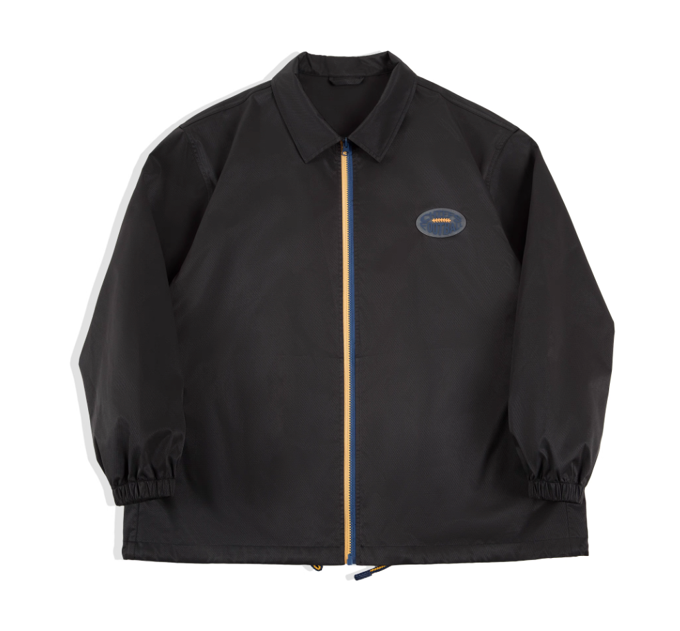Black retro coach jacket with blue-yellow zipper, front view.