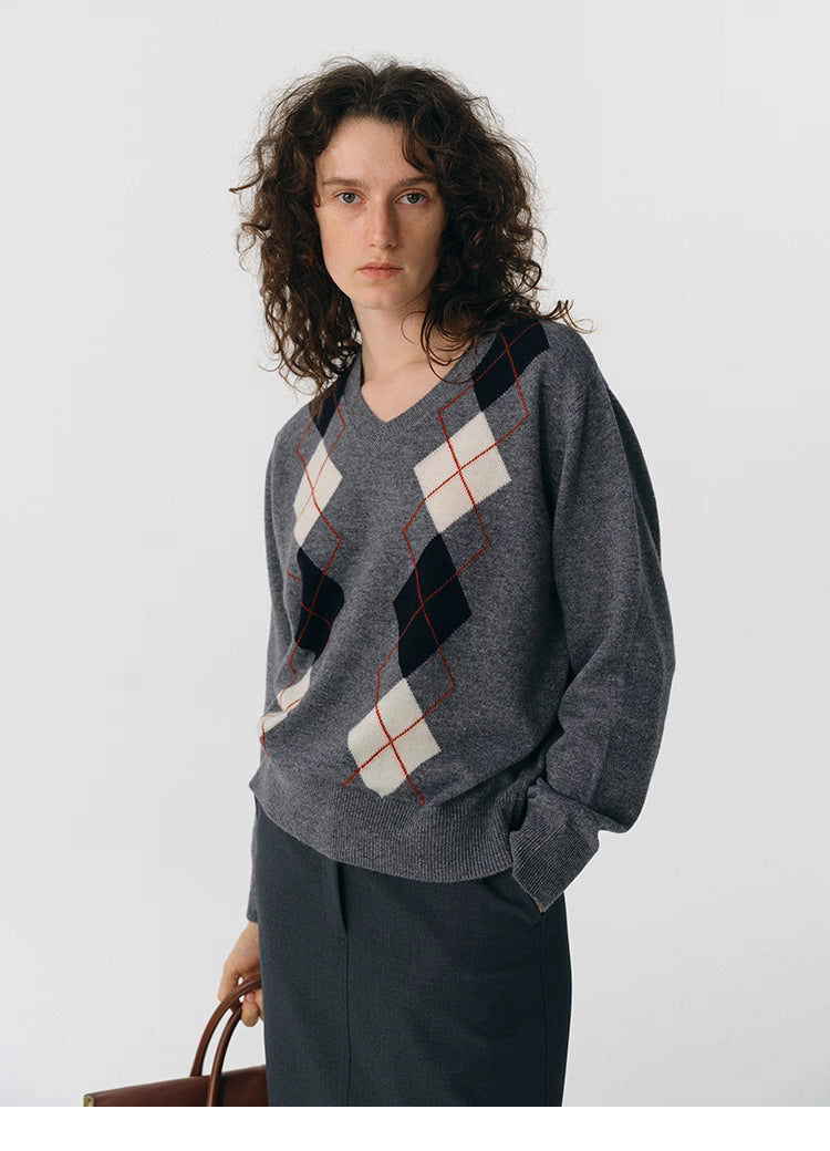Front view of charcoal V-neck wool sweater with ivory and black argyle pattern.