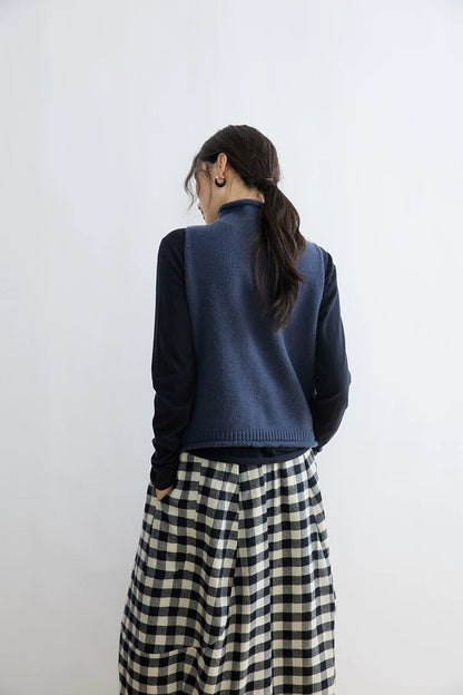 Back view of Ink Blue mock-neck sweater vest layered over a navy long-sleeve top