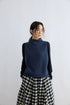 Close-up of Ink Blue 100% wool sweater vest showing rolled mock neck and ribbed hem