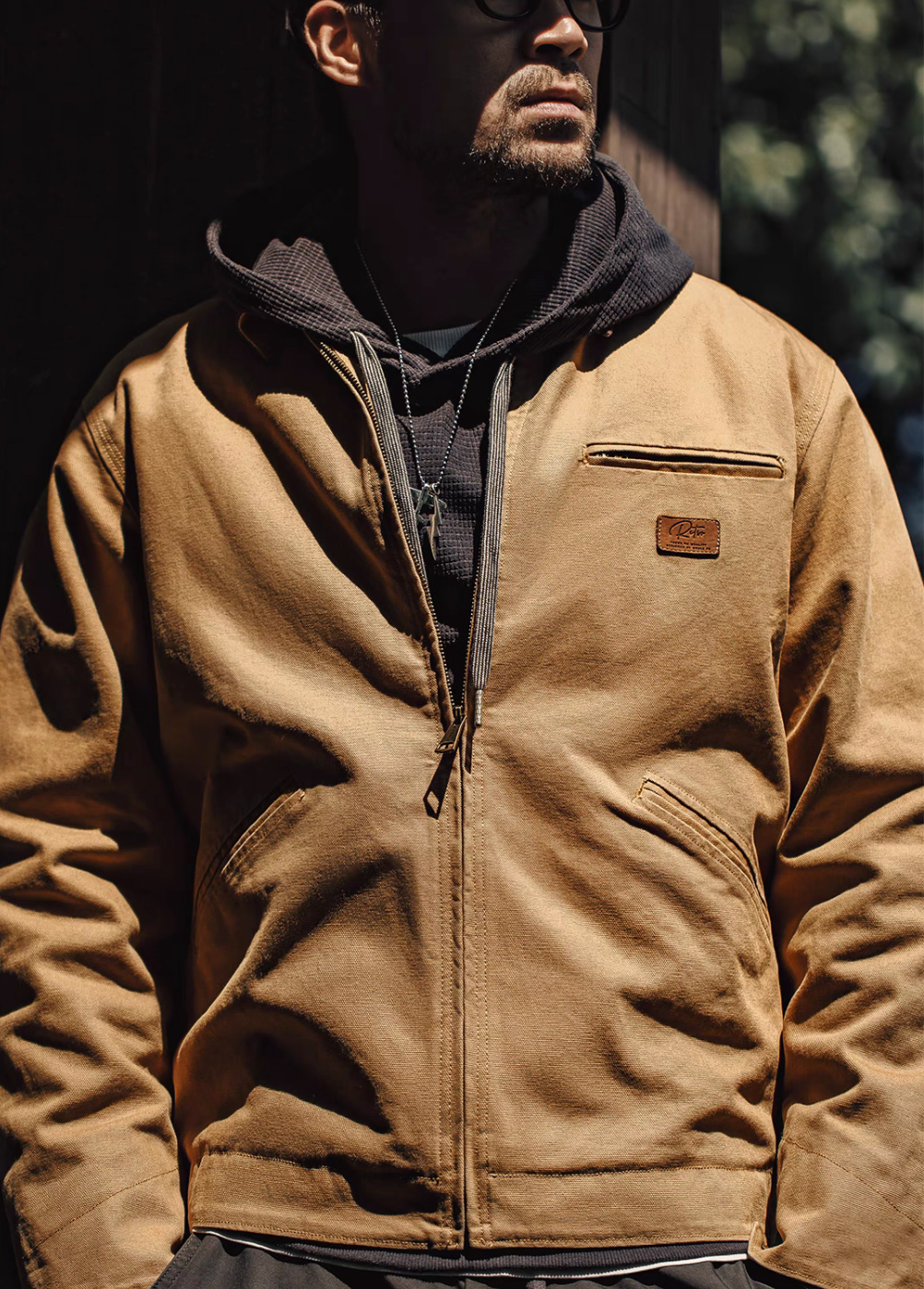 Ironclad Canvas Work Jacket khaki front worn outdoor layered with hoodie showing rugged workwear style and relaxed fit