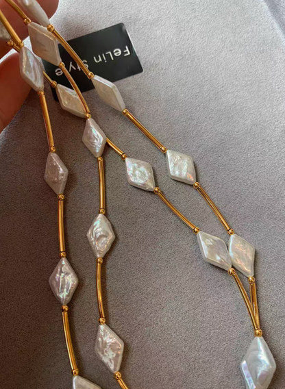Close-up of diamond-shaped freshwater baroque pearls with iridescent surface on 24K gold-plated brass necklace