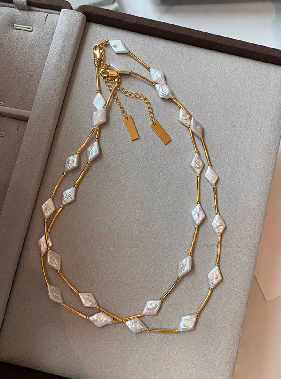 Irregular baroque pearl necklace with diamond-shaped freshwater pearls and 24K gold-plated brass chain displayed on jewelry box