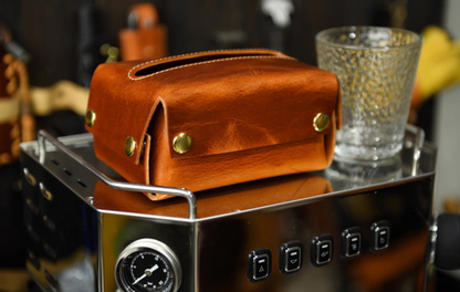 Caramel brown full-grain Italian leather tissue box with brass buttons on espresso machine.
