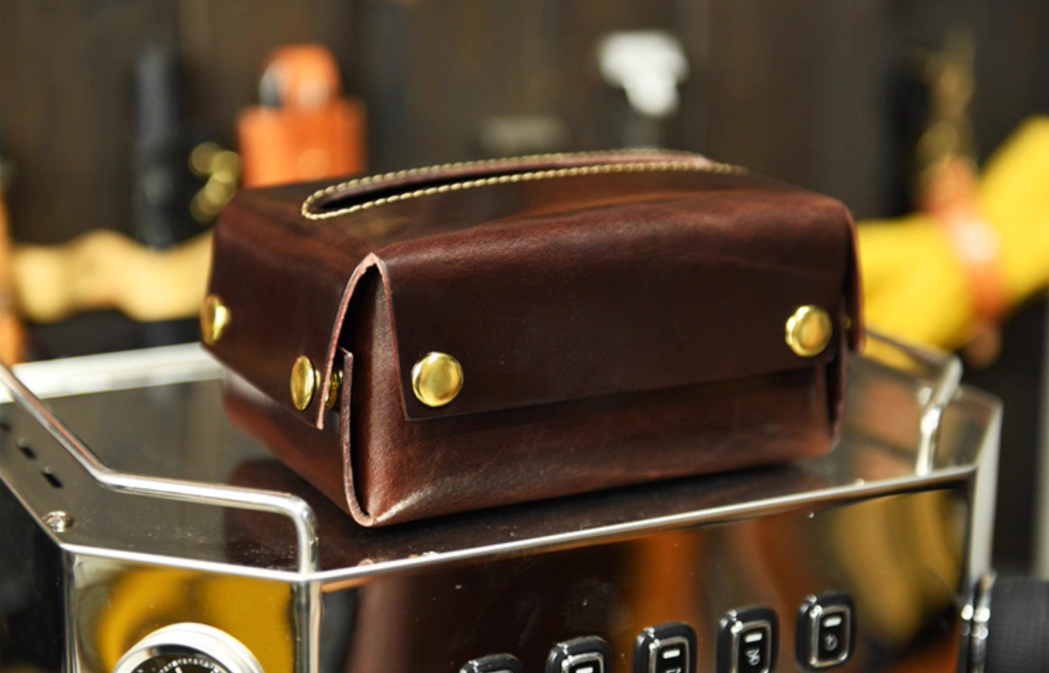 Dark brown Italian leather tissue box with brass snaps placed on espresso machine top.