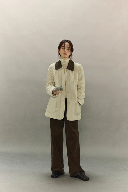 full-body front view of cream quilted barn coat styled with brown pants
