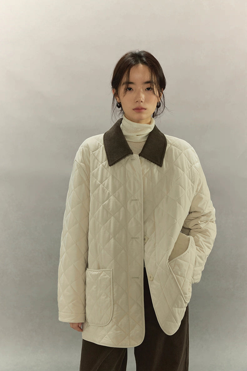 model wearing ivory quilted barn coat with corduroy collar, front view