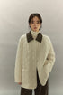 model wearing ivory quilted barn coat with corduroy collar, front view