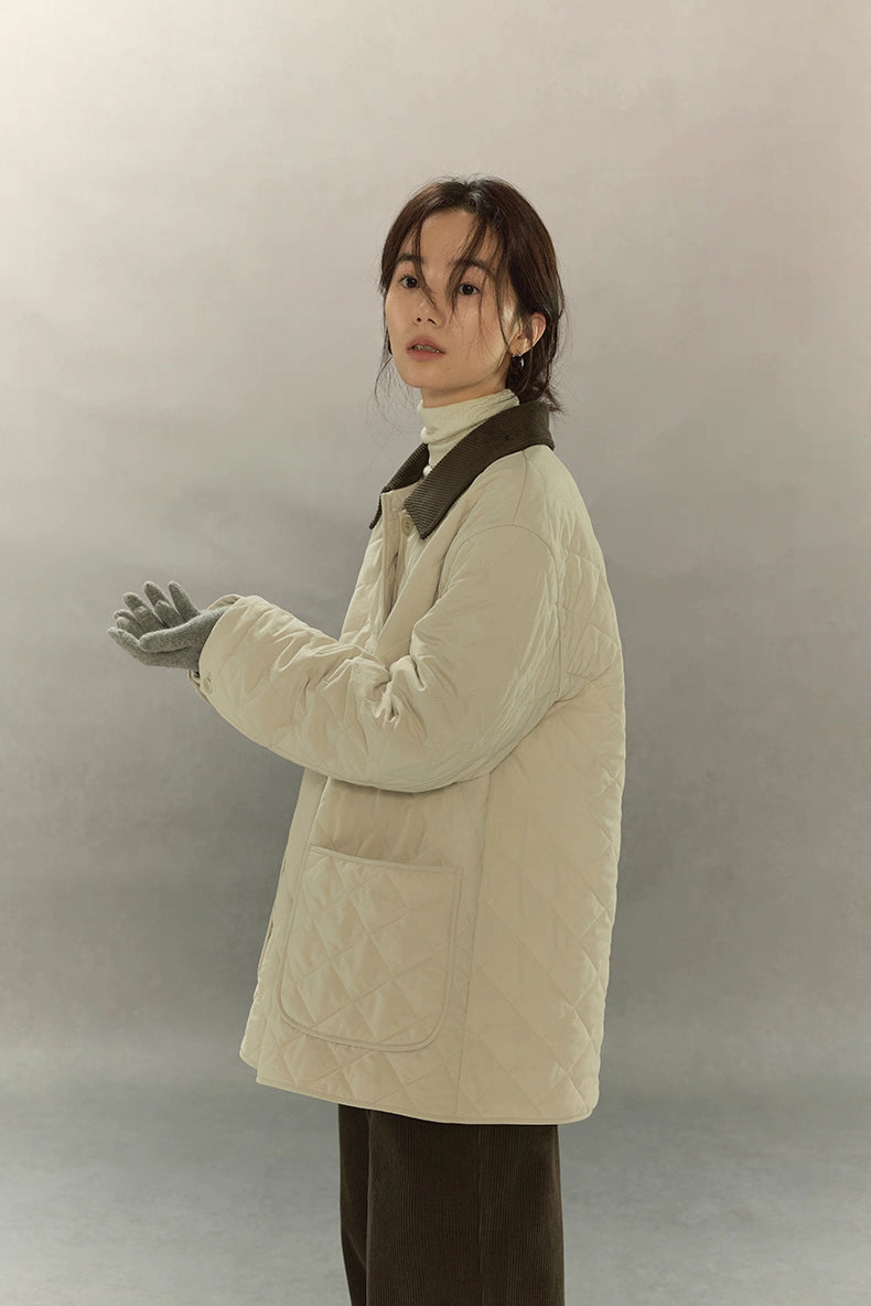 side profile of quilted cream barn coat showing relaxed silhouette