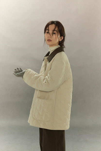 side profile of quilted cream barn coat showing relaxed silhouette