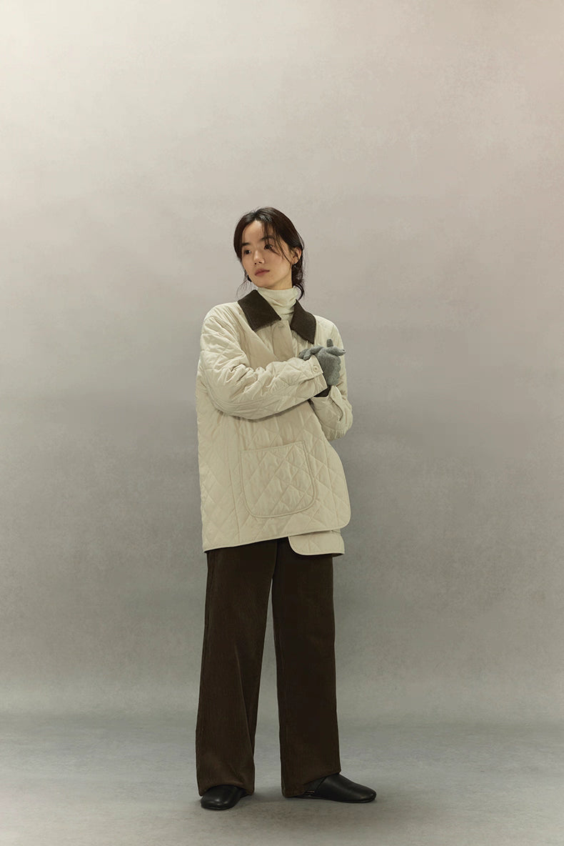 model wearing gloves with cream quilted barn coat, chest-up view