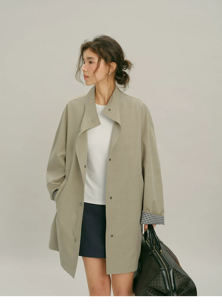 Front view of a Khaki mid-length mac coat worn open with the stand collar folded back