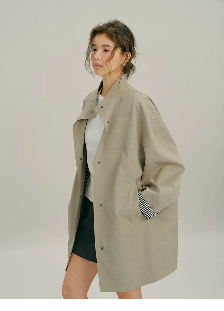 Three-quarter view of an open Khaki mac coat with dropped shoulders and slanted pocket