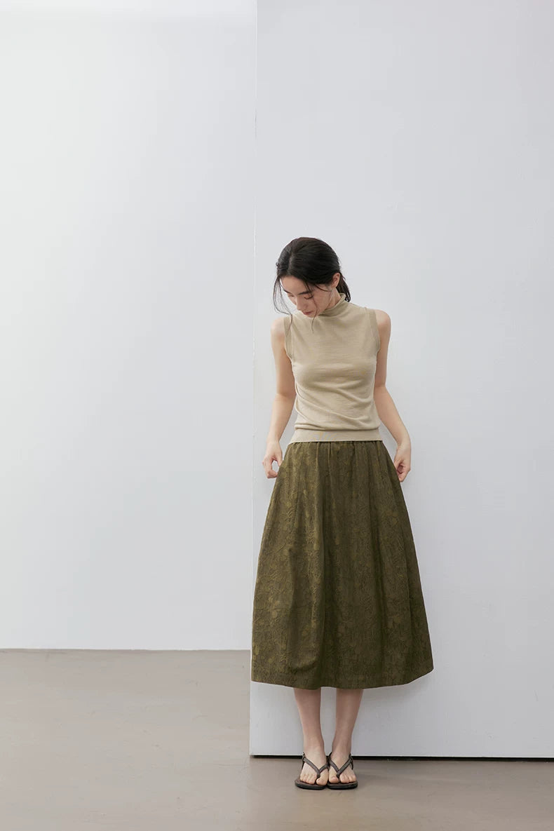 Full-length view of Khaki sleeveless wool blend knit top against a white wall