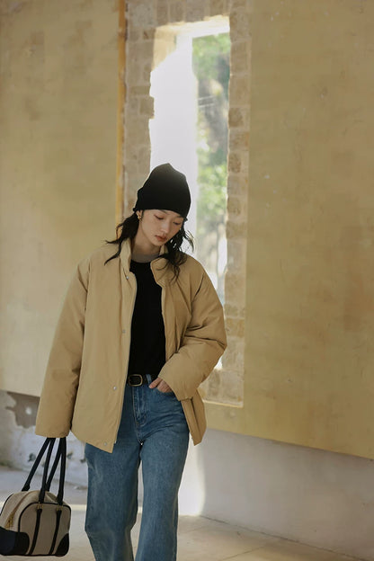 Khaki relaxed down jacket worn open with hand in the side pocket, in motion