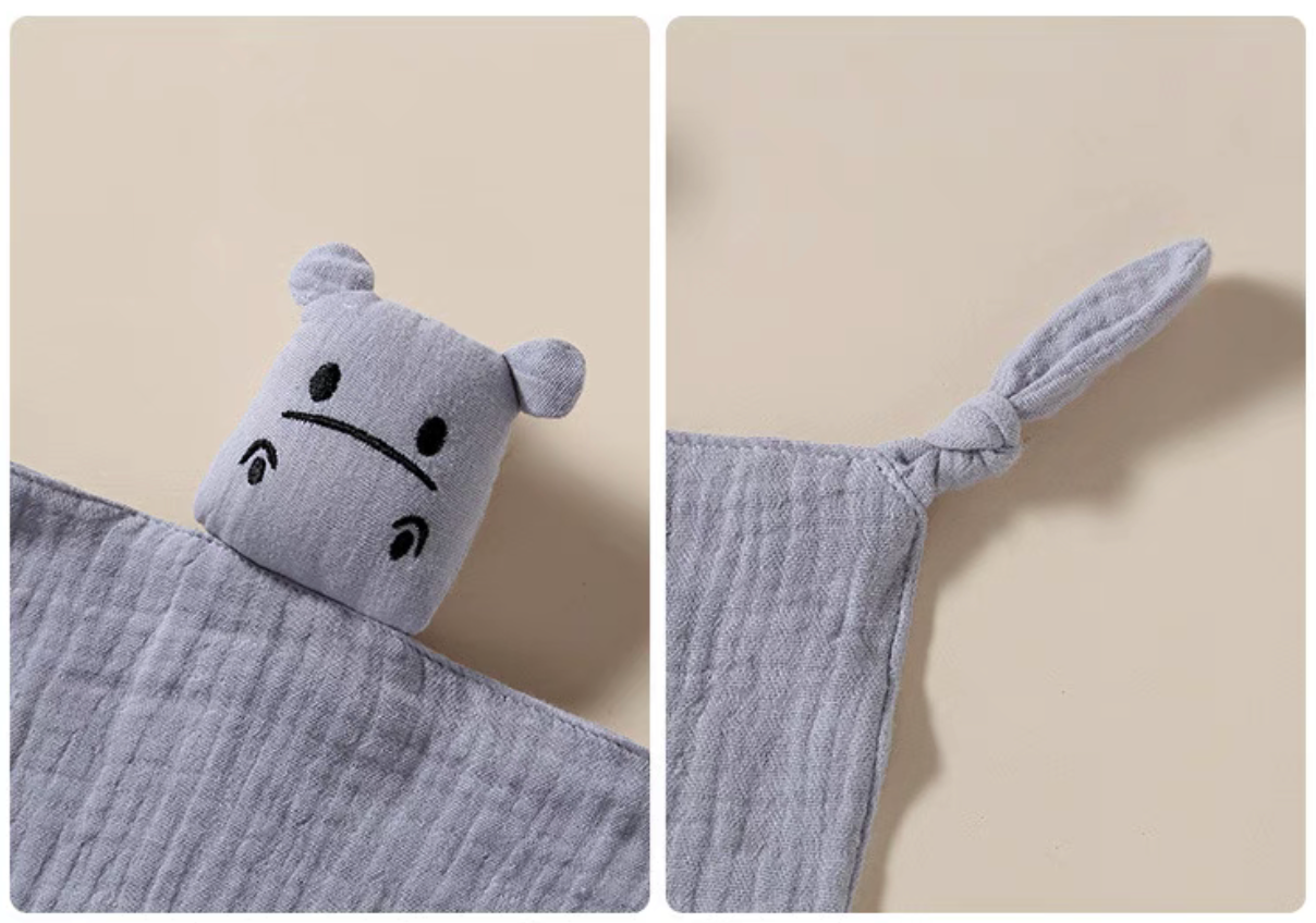 Gray muslin baby lovey close-up showing plush animal head and knotted corner detail
