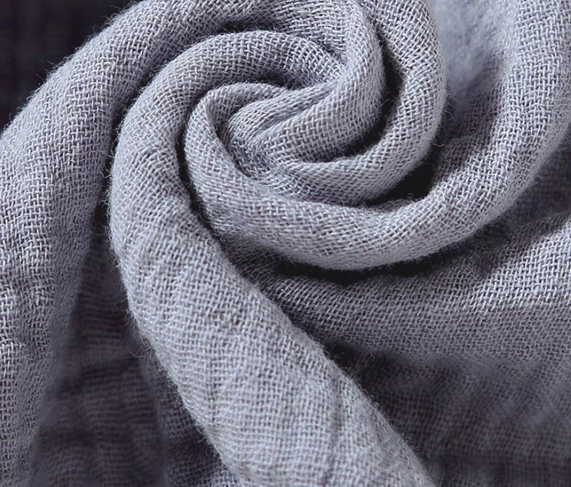 Gray cotton muslin fabric close-up showing breathable soft texture of baby comfort cloth
