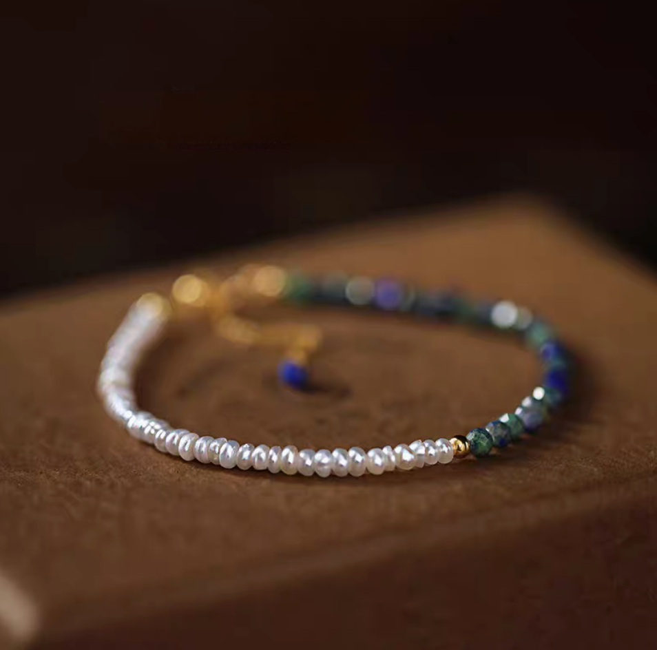 Close-up of lapis pearl bracelet in natural color on wooden surface showing pearl and lapis stone bead texture