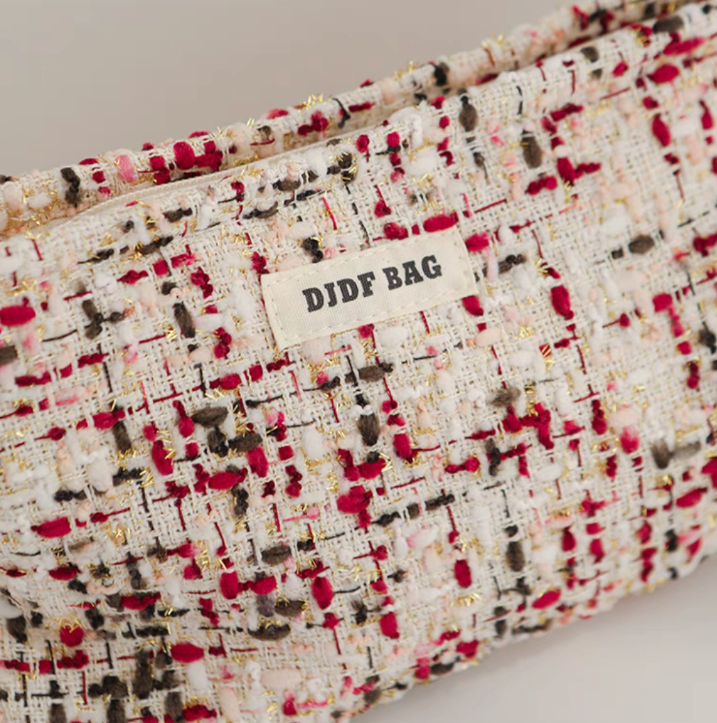 Close-up of Large Capacity Travel Makeup Bag in purple woven texture showing label and detailed fabric pattern