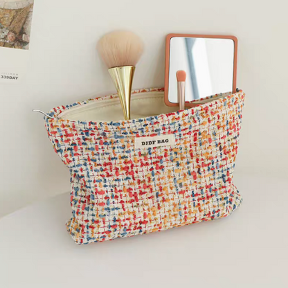 Large Capacity Travel Makeup Bag in red woven texture opened with cosmetic items including brush and skincare tube